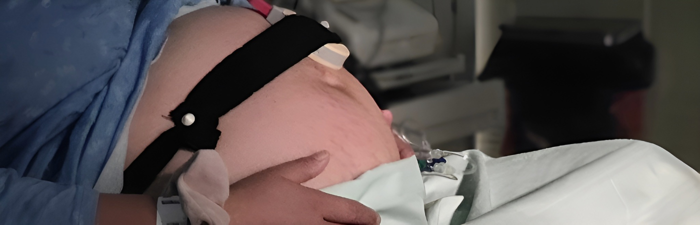 A pregnant woman lying in a hospital bed